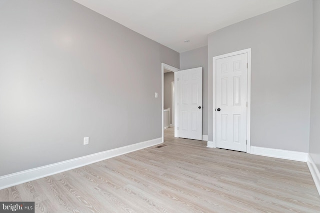 unfurnished bedroom with light hardwood / wood-style flooring and a closet