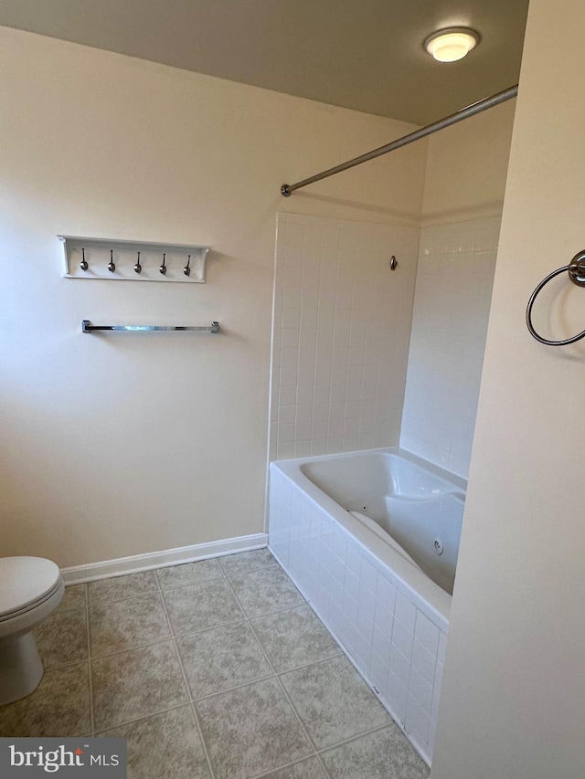 bathroom with tiled shower / bath, tile patterned floors, and toilet