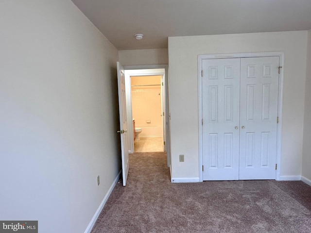 unfurnished bedroom with carpet flooring and a closet