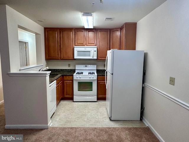 kitchen featuring sink, light carpet, and white appliances