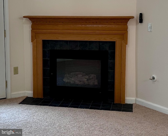 details with a tiled fireplace and carpet floors