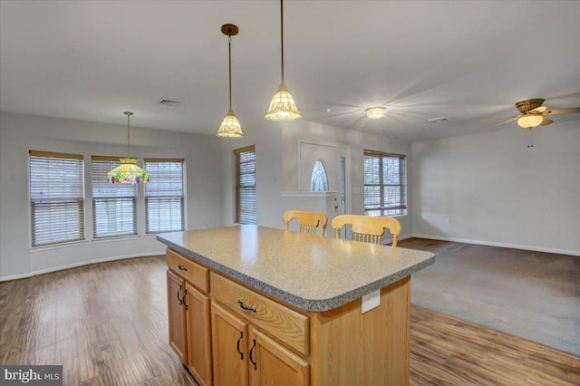 kitchen featuring light hardwood / wood-style flooring, decorative light fixtures, plenty of natural light, and a kitchen island