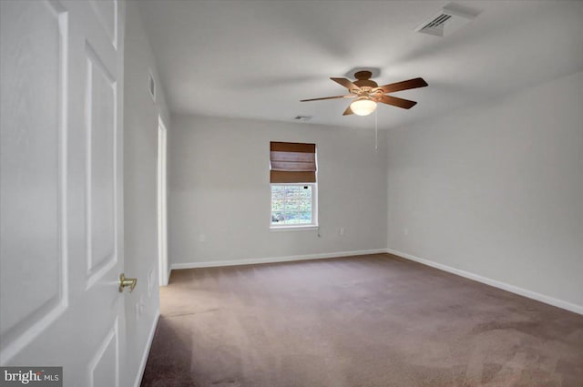 empty room featuring dark carpet and ceiling fan