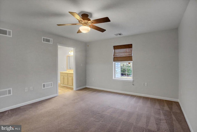 carpeted spare room featuring ceiling fan