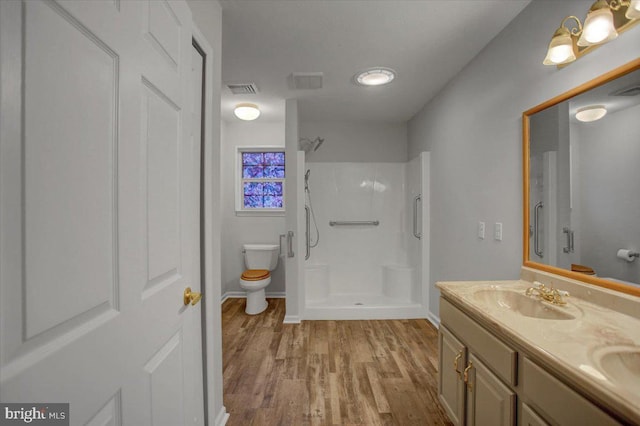 bathroom with vanity, wood-type flooring, toilet, and a shower