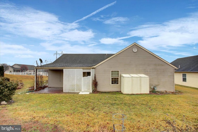 rear view of property with a patio, a shed, and a lawn