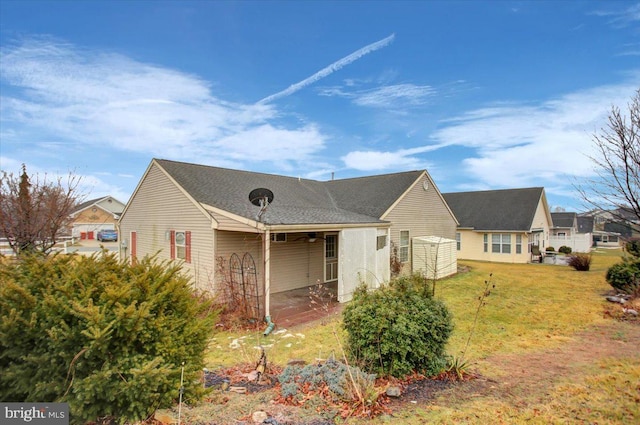 rear view of property featuring a lawn