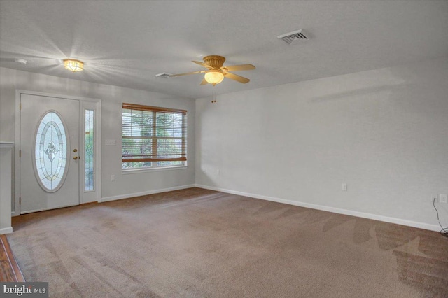 carpeted foyer with ceiling fan and a textured ceiling