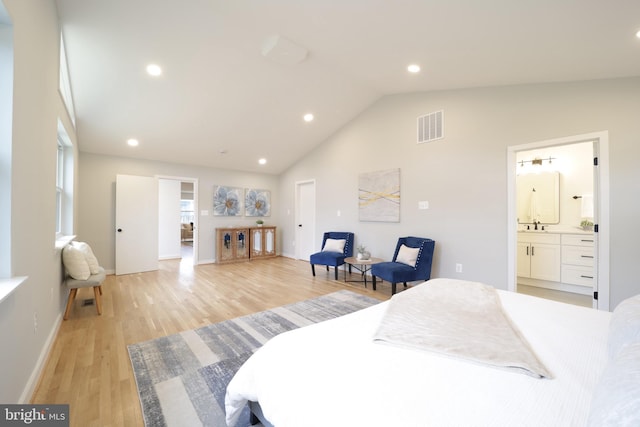 bedroom featuring connected bathroom, vaulted ceiling, light hardwood / wood-style floors, and sink