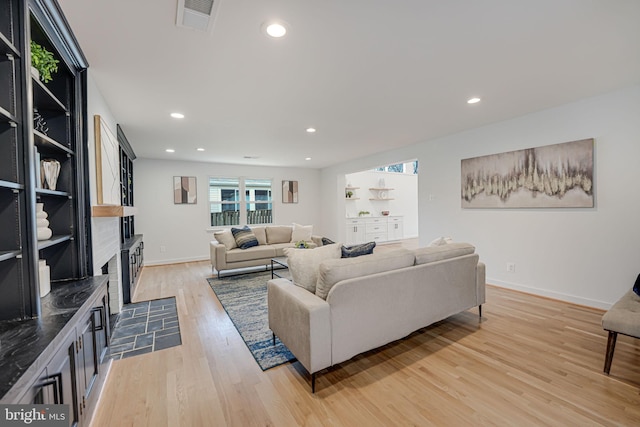 living room featuring a fireplace and light wood-type flooring