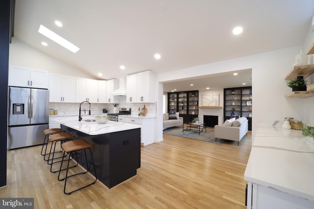 kitchen with appliances with stainless steel finishes, light stone countertops, custom exhaust hood, and white cabinets