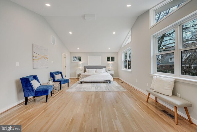 bedroom featuring high vaulted ceiling, light hardwood / wood-style floors, and multiple windows