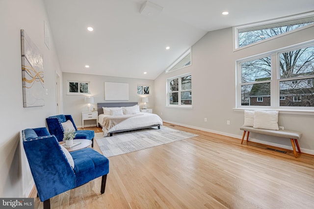 bedroom with high vaulted ceiling and light wood-type flooring