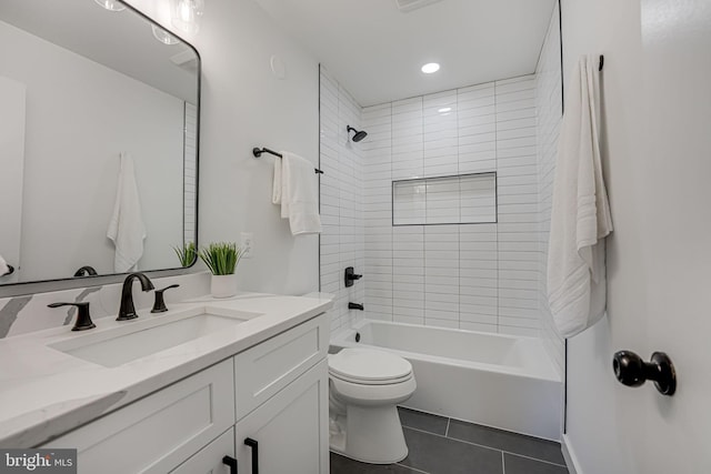 full bathroom featuring tiled shower / bath combo, vanity, tile patterned floors, and toilet