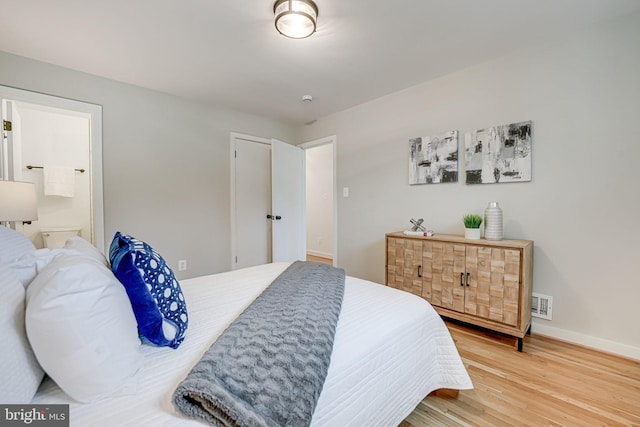 bedroom featuring connected bathroom and hardwood / wood-style floors