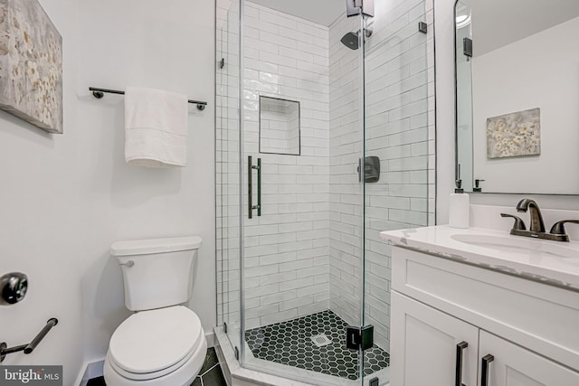 bathroom with an enclosed shower, vanity, and toilet