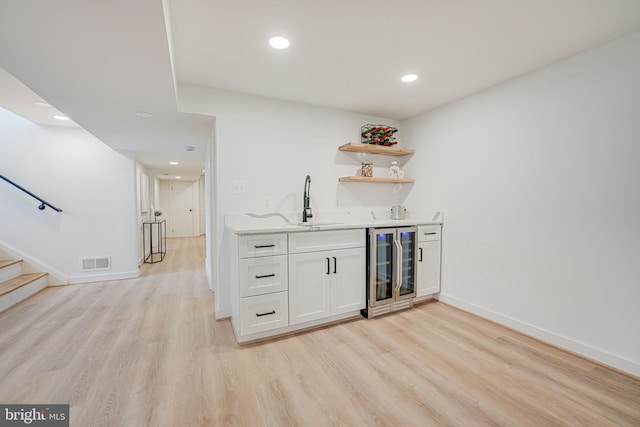 bar featuring white cabinetry, sink, wine cooler, and light hardwood / wood-style flooring