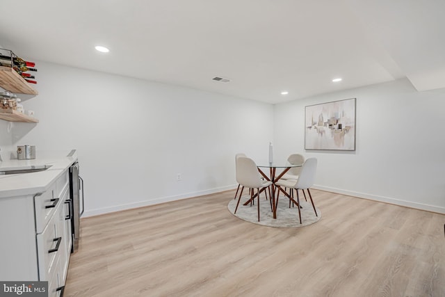 unfurnished dining area featuring sink and light hardwood / wood-style flooring