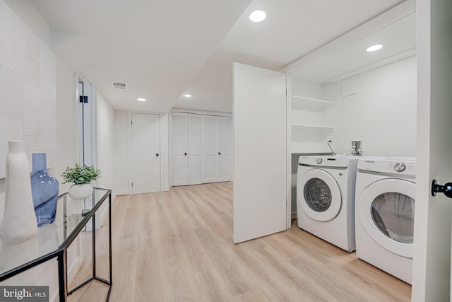 laundry area featuring light hardwood / wood-style flooring and washing machine and clothes dryer