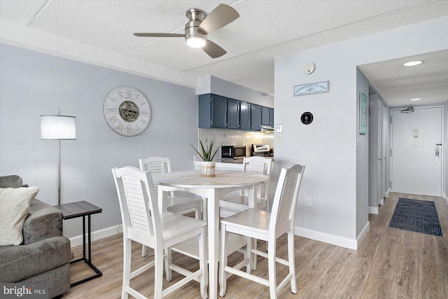 dining space featuring ceiling fan, a textured ceiling, and light wood-type flooring