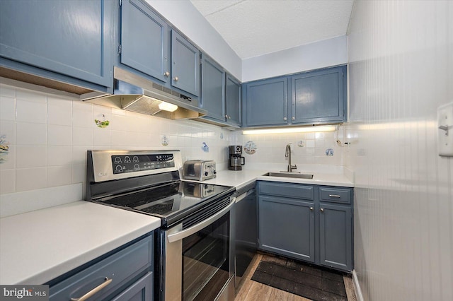 kitchen with sink, blue cabinetry, a textured ceiling, decorative backsplash, and stainless steel electric stove