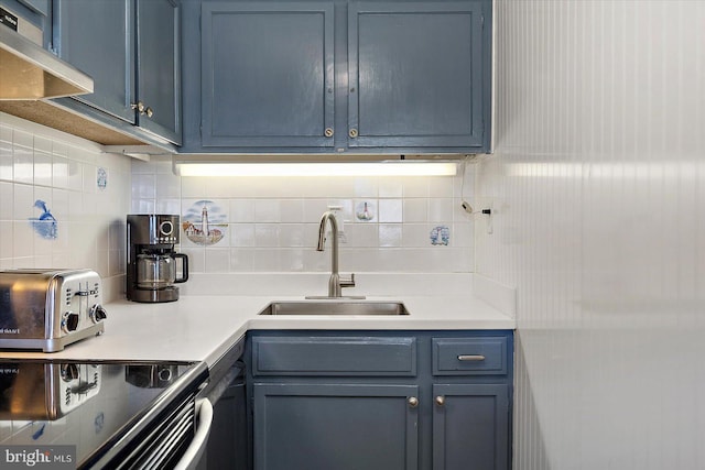 kitchen with ventilation hood, tasteful backsplash, sink, and blue cabinets