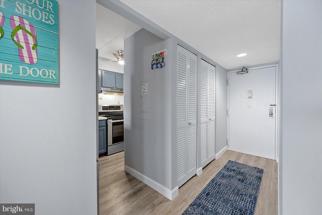 hallway featuring a textured ceiling and light wood-type flooring