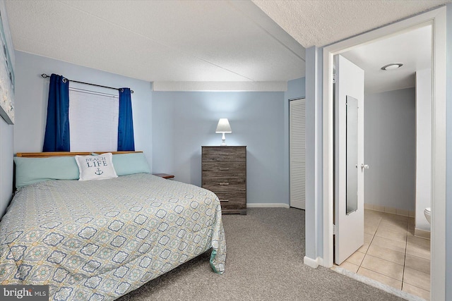 bedroom featuring light carpet and a textured ceiling