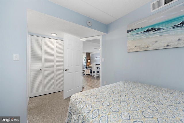 carpeted bedroom with a closet and a textured ceiling