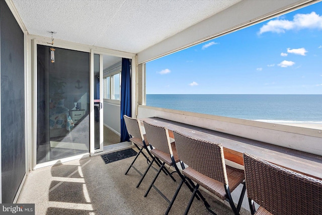 balcony featuring a beach view and a water view