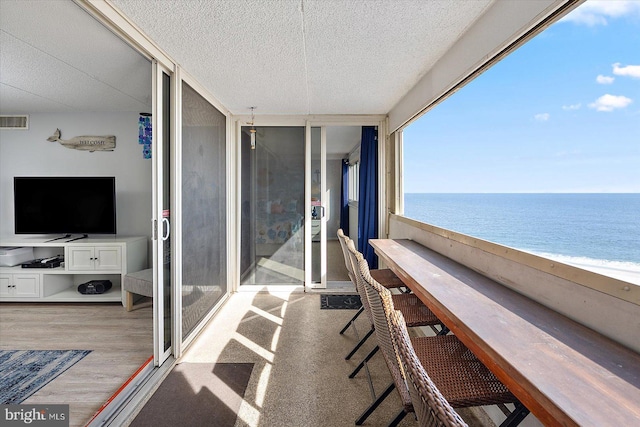 balcony with a water view and a beach view