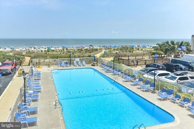 view of pool featuring a water view and a patio area