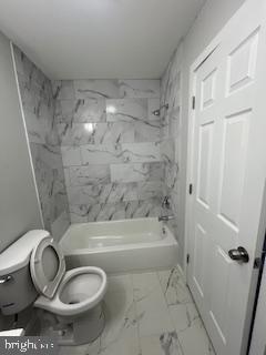 bathroom with toilet and shower / bath combination