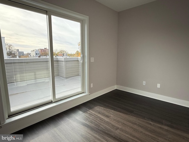 unfurnished room with plenty of natural light and dark hardwood / wood-style flooring