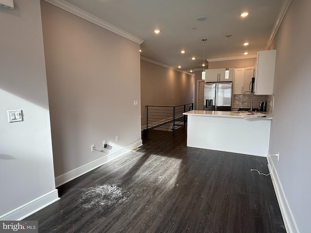 kitchen with pendant lighting, stainless steel appliances, dark hardwood / wood-style floors, white cabinets, and kitchen peninsula