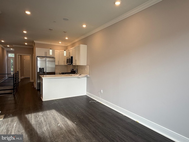 kitchen featuring white cabinetry, hanging light fixtures, stainless steel appliances, dark hardwood / wood-style flooring, and kitchen peninsula