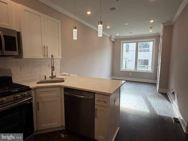 kitchen with sink, tasteful backsplash, appliances with stainless steel finishes, pendant lighting, and white cabinets