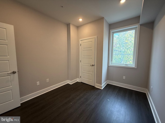 unfurnished bedroom with dark wood-type flooring