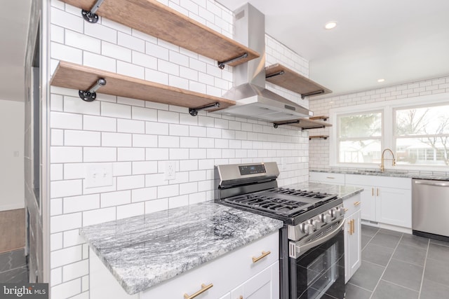 kitchen featuring sink, appliances with stainless steel finishes, light stone counters, tasteful backsplash, and white cabinets