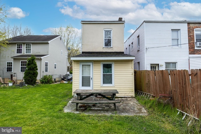 rear view of property with a lawn