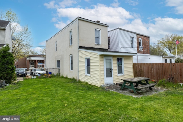 rear view of property featuring a lawn