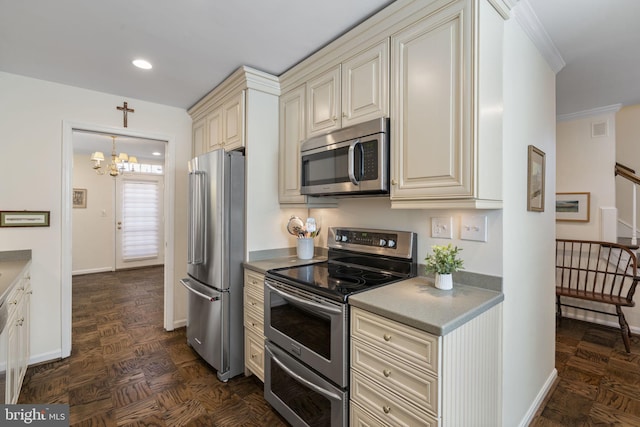 kitchen featuring pendant lighting, appliances with stainless steel finishes, cream cabinets, a notable chandelier, and dark parquet floors