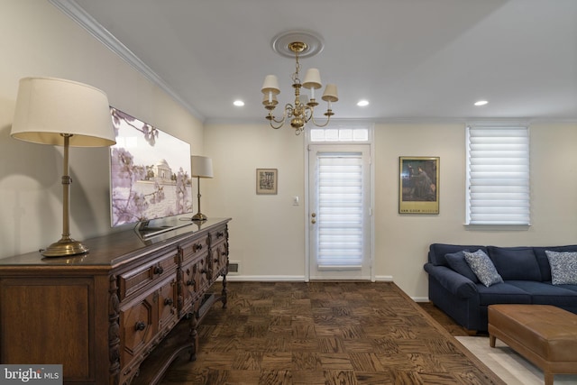 entrance foyer featuring an inviting chandelier, ornamental molding, and dark parquet flooring