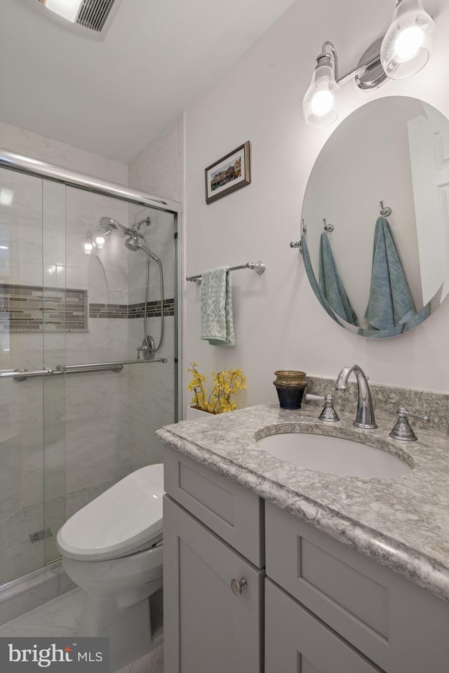 bathroom with vanity, toilet, and an enclosed shower