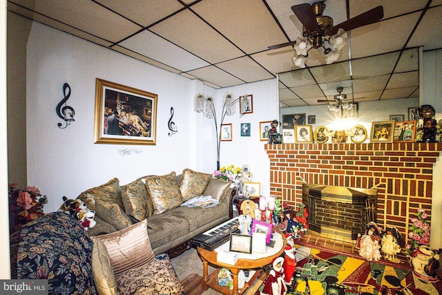 living room with a paneled ceiling, a fireplace, and ceiling fan