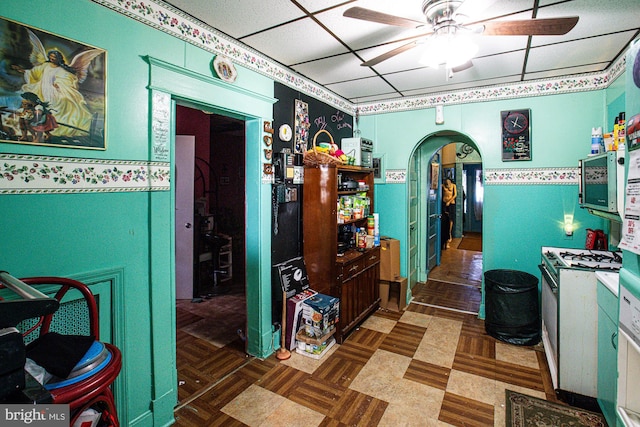 kitchen featuring ceiling fan, a paneled ceiling, and dark parquet floors