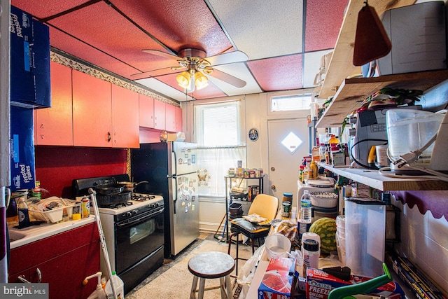 kitchen with white range with gas stovetop, stainless steel fridge, and ceiling fan