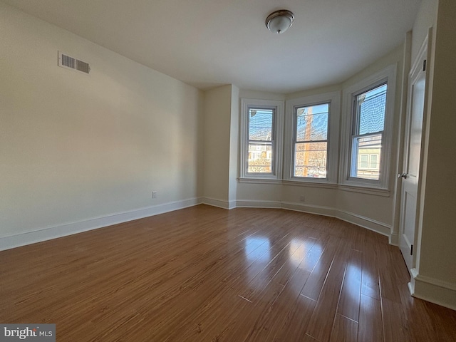 unfurnished room with dark wood-type flooring