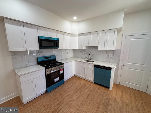 kitchen featuring tasteful backsplash, appliances with stainless steel finishes, sink, and white cabinets