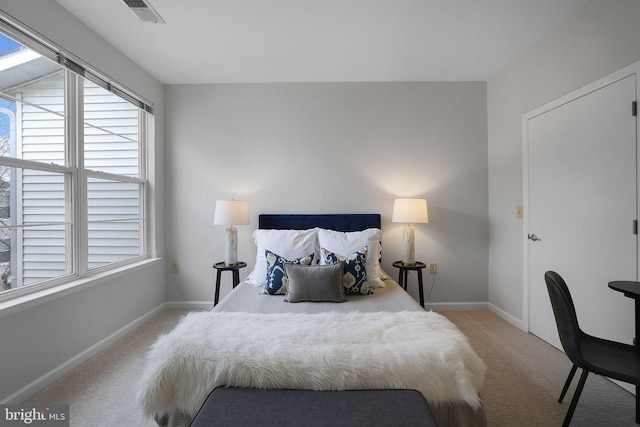 bedroom with light carpet, visible vents, and baseboards